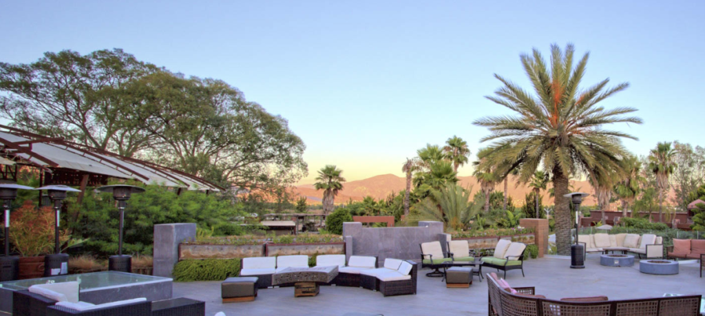 Outdoor patio with comfortable seating, fire pits, and views of the Valle de Guadalupe at Fuego Cocina Del Valle. Valle de Guadalupe Mexico Tour.