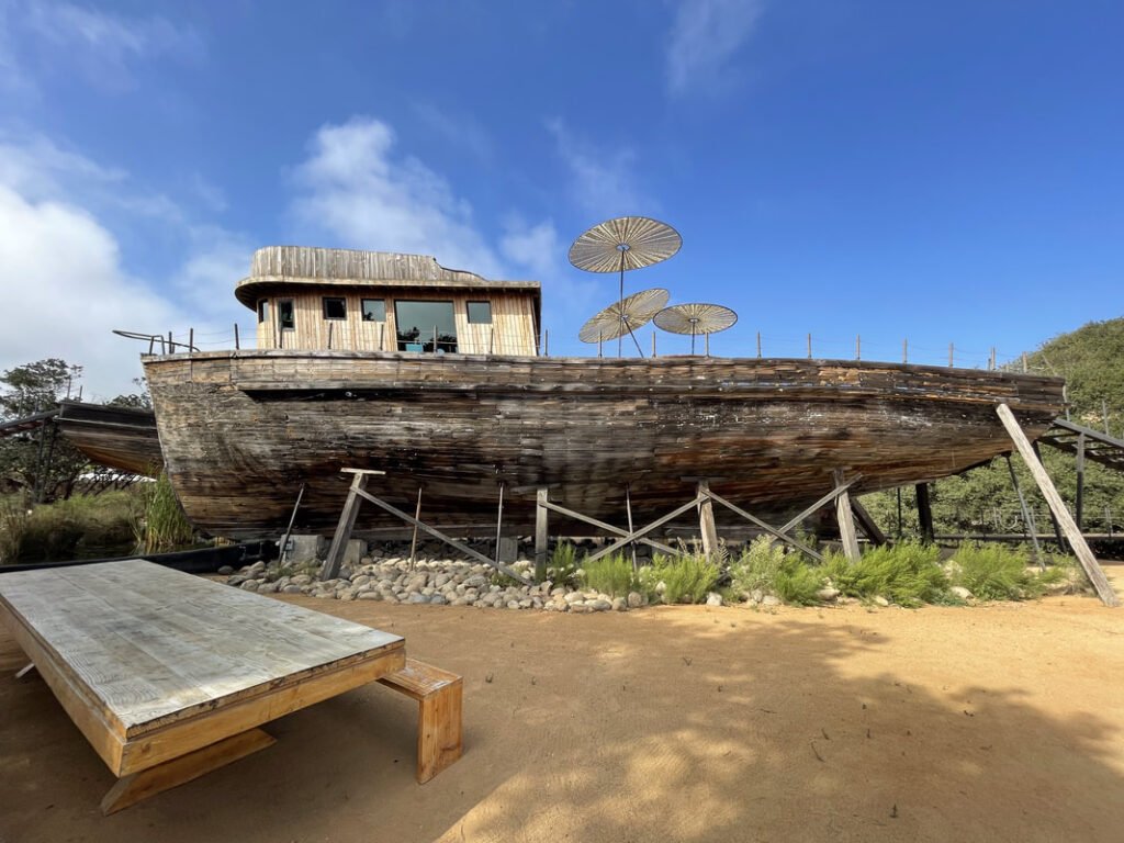 A repurposed wooden boat used as part of the outdoor dining area at Tahona Baja Mezcal Bar and Restaurant in the Valle de Guadalupe. Valle de Guadalupe Mexico Tour.