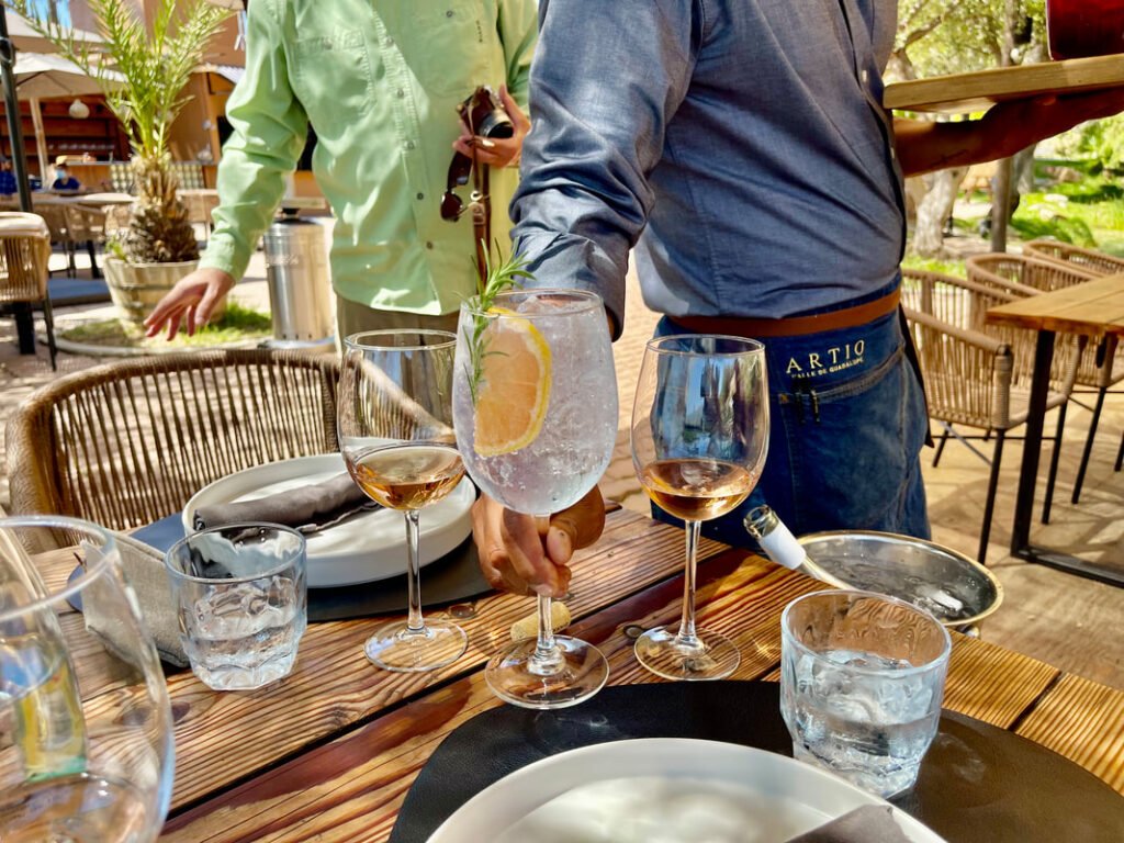 An inviting table setting with elegant beverages awaits you in the scenic outdoor ambiance of Mexico wine tours.